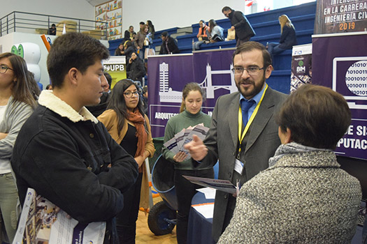 Foto 4. Jefes de carrera explicando a padres e hijos las diferentes carreras de la UPB durante la feria